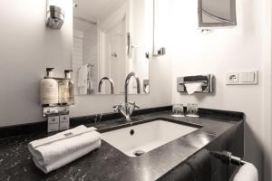 łazienka z umywalką i dużym lustrem w obiekcie Hotel Borg by Keahotels w Reykjavík