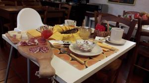 una mesa con queso y otros alimentos. en Casa Del Noce, en Rovereto