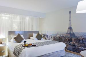 a bedroom with a bed with a view of the eiffel tower at Mercure Paris Vaugirard Porte De Versailles in Paris