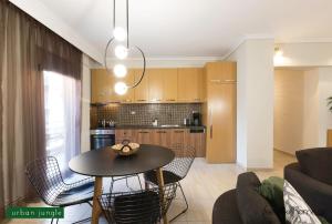 a living room with a table and chairs and a kitchen at #FLH - Urban Apartments in Thessaloniki