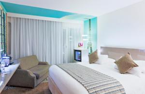 ein Hotelzimmer mit einem Bett und einem Stuhl in der Unterkunft Mercure Paris Vaugirard Porte De Versailles in Paris