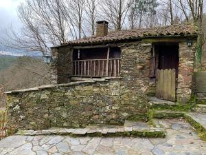 an old stone building with a window and a door at Casa do Tanque in Lousã