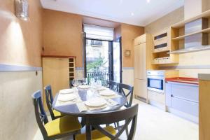 a kitchen with a table with chairs and a dining room at The Rentals Collection | Camelot in San Sebastián