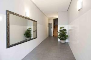 un corridoio con due piante in vaso e un grande specchio di The Rentals Collection | Verona a San Sebastián
