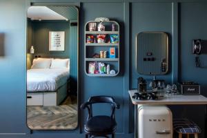 sypialnia z lustrem, łóżkiem i biurkiem w obiekcie The Devlin Dublin w Dublinie