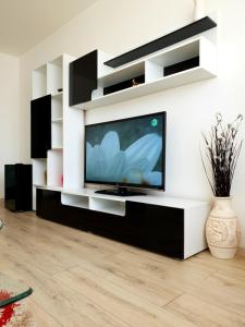 a living room with a flat screen tv on a white wall at Studio Central in Piatra Neamţ