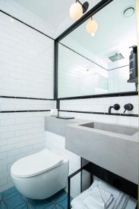 a bathroom with a white toilet and a sink at The Devlin Dublin in Dublin