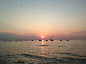 een zonsondergang over het water met boten in het water bij Ferienwohnung Ostseetraum in Rostock
