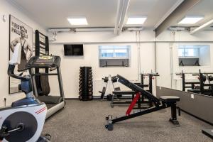 a gym with treadmills and machines in a room at Thomas' Home - Trendy, Central & Balcony in Tallinn