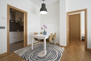 una sala da pranzo con tavolo e sedie su un tappeto di The Rentals Collection | Avenida II a San Sebastián