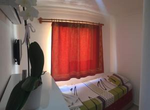 a bedroom with a red curtain and a bed in front of a window at REKOR OTEl in Antalya