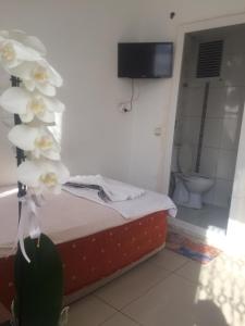 a bedroom with a bed and a bathroom with a toilet at REKOR OTEl in Antalya