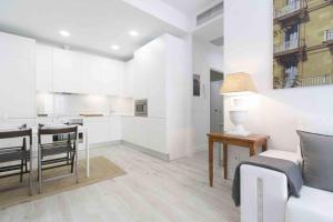a white apartment with a kitchen and a dining room at The Rentals Collection | Okendo I in San Sebastián