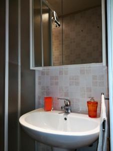 La salle de bains est pourvue d'un lavabo blanc et d'un miroir. dans l'établissement Le Malte, à Menton