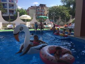 two children are riding on an inner tube in a swimming pool at Hotel Sapphire in Primorsko