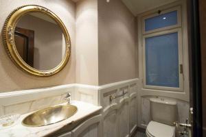 łazienka z umywalką, toaletą i lustrem w obiekcie The Rentals Collection | BellaVista w mieście San Sebastián +10 zdjęć