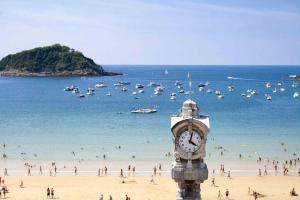 wieża zegarowa na plaży z tłumem ludzi w obiekcie The Rentals Collection | BellaVista w mieście San Sebastián