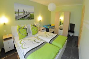 a bedroom with a large bed with green accents at Ferienhaus Müritzidyll / EG-Appartement in Marienfelde