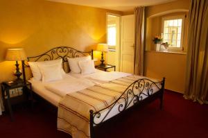 a bedroom with a large bed with white sheets and pillows at Galerie Hotel in Paderborn