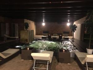 a pool in a building with chairs and lights at Foro Appio Mansio Hotel in Latina