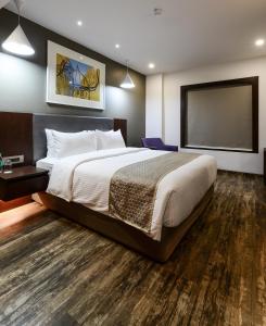 a bedroom with a large bed and a flat screen tv at Howard Johnson by Wyndham, Kolkata Airport in Kolkata