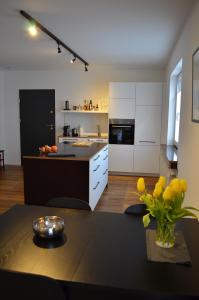 eine Küche mit weißen Schränken und einem Tisch mit gelben Blumen in der Unterkunft Apartment Pfungstadt in Pfungstadt