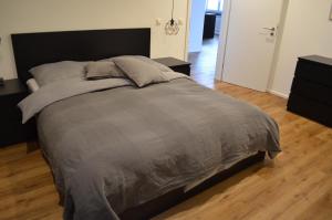 Schlafzimmer mit einem großen Bett mit einem schwarzen Kopfteil in der Unterkunft Apartment Pfungstadt in Pfungstadt