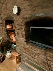 una televisione su un muro di pietra in una stanza di Casa do Tanque a Lousã