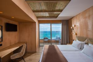 a hotel room with a bed and a view of the ocean at Palmera Beach Hotel & Spa - Adults Only in Hersonissos