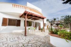 een terras van een wit huis met een pergola bij Le Gioie - Dimora Scalelle - Villetta con giardino e veranda vista mare in Torre Vado