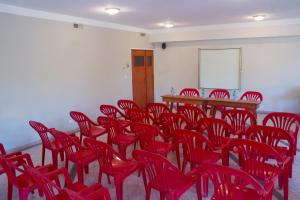 a room filled with red chairs and a table at Cabañas del Golf in La Cumbre +20 photos