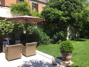 een patio met stoelen en een parasol in de tuin bij Primaluce in Venetië