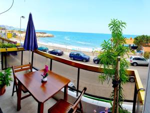 uma mesa e cadeiras numa varanda com vista para a praia em AlSaeed Residence em Jounieh