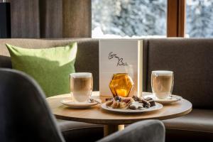 una mesa con dos tazas y un plato de comida en ella en Cresta.Alpin.Sport.Hotel, en Lech am Arlberg