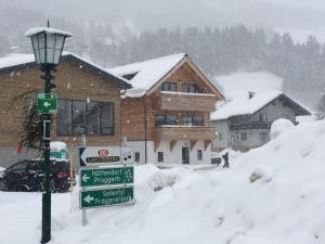 a street sign in the snow in front of a house at HS - Rockhaus in Pruggern