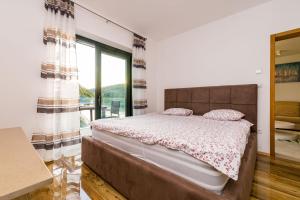 a bedroom with a large bed and a large window at Barbara in Molunat