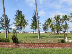 einen Park mit Palmen und Ziegelwand in der Unterkunft Sea View Resort Hotel & Apartments in Kuala Belait