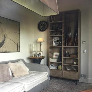 sala de estar con sofá y estante para libros en B&B Goed Ten Hulle, en Pittem