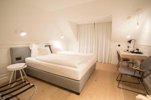 a bedroom with a bed and a desk and a table and chairs at De Sjeiven Dorpel in Maaseik