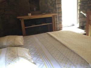 Ce lit se trouve dans un dortoir doté d'une table en bois. dans l'établissement Casetta, à Olivese