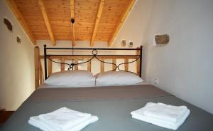 a bedroom with a bed with two towels on it at Christos Raches traditional houses in Raches