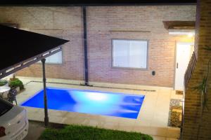 una gran piscina azul frente a un edificio de ladrillo en Complejo Cortazar Rafaela en Rafaela