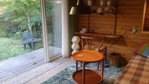 eine Veranda einer Hütte mit einem Schreibtisch und einem Stuhl in der Unterkunft Tajimi Guest House in Tajimi