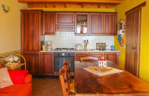 eine Küche mit einem Holztisch und einem Herd Top-Backofen in der Unterkunft Chalet Casa Melissa in Vercana