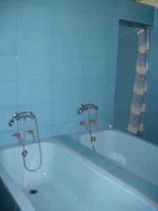 a bath tub with two faucets in a bathroom at Hotel Traian Eforie Nord in Eforie Nord