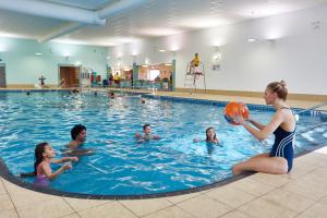 a woman playing with a ball in a swimming pool at Southview Park Hotel in Skegness