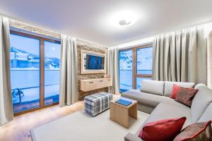 a living room with a couch and large windows at Piccard Nº 5 in Obergurgl
