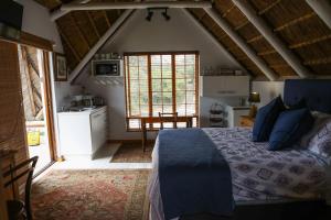 1 dormitorio con 1 cama con edredón azul en Milkwood Way, en St Francis Bay