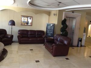 una sala de espera con sofás de cuero marrón y un cartel en Hotel Real de Uruapan, en Uruapan del Progreso