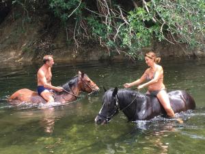 un hombre y una mujer montando caballos en el agua en Casetta en Olivese